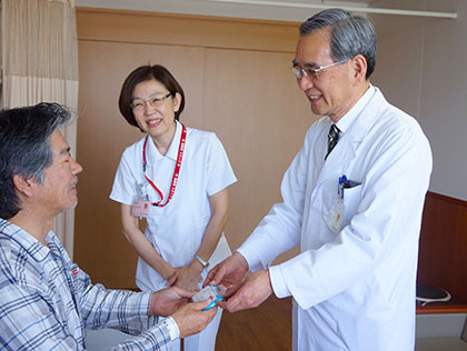 田内潤院長（右）から入院患者にメッセージカードと記念品が贈られた