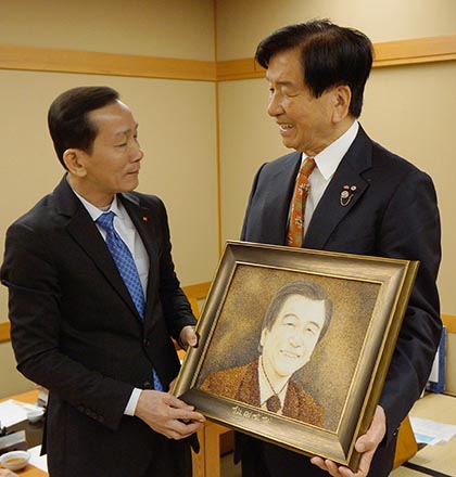 トン人民委員長（左）から加藤均理事長にベトナム米で作られた肖像画が贈られた