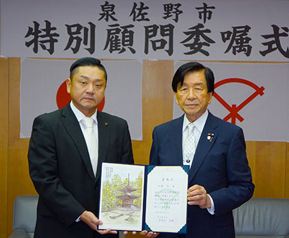 千代松 大耕 泉佐野市長（左）から加藤均理事長に委嘱状が交付された