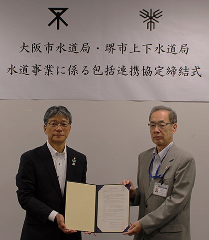 大阪市の河谷水道事業管理者（右）と出耒堺市上下水道事業管理者（左）で協定が締結された。