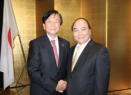固い握手を交わすグエン・スアン・フック首相（右）と加藤均理事長（左）（平成29年６月８日・大阪市内で）