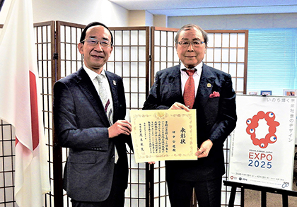 「外務大臣表彰」授与式で特命全権大使 山本条太氏（左）から授与される田中氏