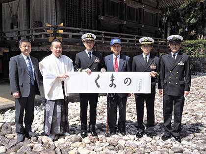 熊野本宮本殿の前で揮毫が披露された（左から２人目 九宮司、同３人目 櫻井員長、同４人目 加藤均会長）